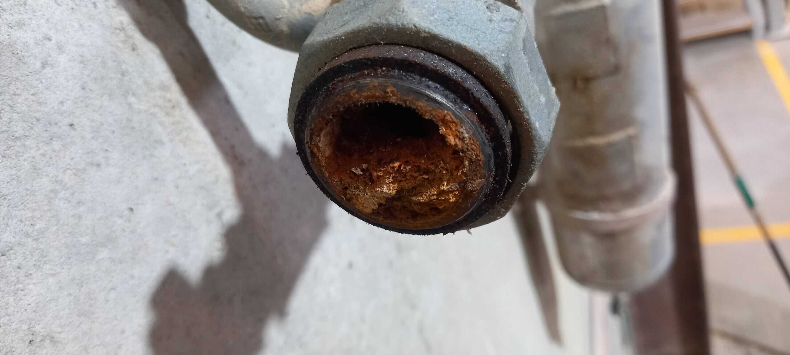 A galvanised air pipe in an industrial compressed air installation. The pipe is clogged with rust flakes.